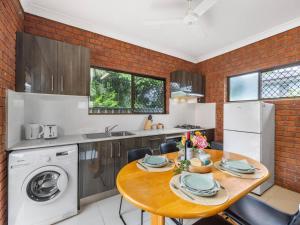 a kitchen with a table and a washer and dryer at 1 Bedroom Comfy Unit Sleep 3 close to mall and bus in Brisbane