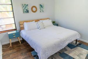 a bedroom with a bed with white sheets and a window at Hidden Gem Off Atlantic Ave, Just Steps From Beach in Delray Beach