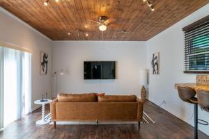 a living room with a couch and a flat screen tv at Hidden Gem Off Atlantic Ave, Just Steps From Beach in Delray Beach