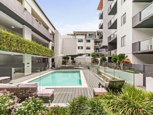 an apartment patio with a swimming pool in a building at Chic Modern Retreat 1BR Apt w pool Kelvin Grove in Brisbane