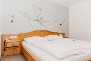 Bett in einem Schlafzimmer mit Wandzeichnung in der Unterkunft Hotel Grünwaldkopf in Obertauern