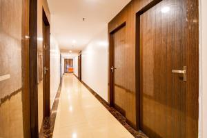 a corridor with wooden doors and a long hallway at Collection O by OYO Flavour in Āsansol