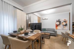 ein Esszimmer und ein Wohnzimmer mit einem Tisch und Stühlen in der Unterkunft P deluxe suites 4 in Thessaloniki