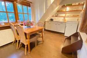 een keuken met een houten tafel en een aantal stoelen bij Gezellige vakantieboerderij voor 14 personen in De Lutte