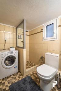 ein Badezimmer mit einem WC und einer Waschmaschine in der Unterkunft P deluxe suites 4 in Thessaloniki