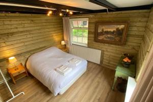 een slaapkamer met een bed in een houten muur bij Gezellige vakantieboerderij voor 14 personen in De Lutte