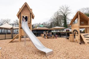 a playground with a slide at a park at Camping de Konijnenberg Tiny House in Harderwijk