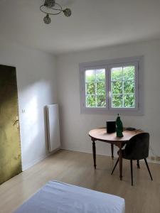 een witte kamer met een tafel en een raam bij Maison de 5 chambres avec jardin clos et wifi a Dammartin en Goele in Dammartin-en-Goële