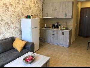 a living room with a white refrigerator and a kitchen at Bakuriani Park Recidence Apartment in Bakuriani