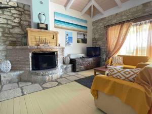 uma sala de estar com uma lareira de pedra e um sofá em Family Cottage with private pool in Vafkeri, Lefkada em Vavkerí