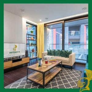 a living room with a couch and a table at The Embassy Suite Two Bedrooms Devereux Residences in London