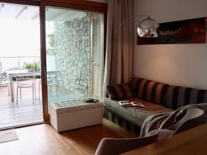 ein Wohnzimmer mit Couch und Tisch und ein Balkon in der Unterkunft Portopiccolo Apartments - Loggia sul mare in Sistiana