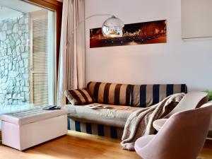 ein Wohnzimmer mit einer Couch und einem Fenster in der Unterkunft Portopiccolo Apartments - Loggia sul mare in Sistiana
