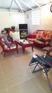 sala de estar con sofá, mesa y sillas en Maison d'une chambre avec jardin amenage et wifi a Petit Bourg, en Petit-Bourg