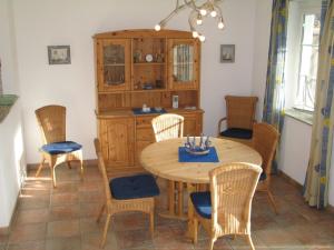 een eetkamer met een houten tafel en stoelen bij Ferienwohnung Sünnenkringel 57 in Zingst