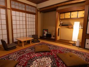 a room with a large oriental rug on the floor at HOSTEL KURIYA OSAKA in Izumi-Sano