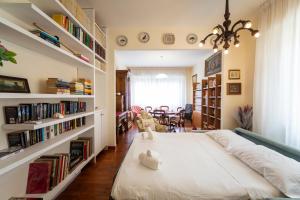 een slaapkamer met een groot wit bed en boekenplanken bij Bright flat close to the centre in Florence