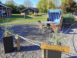 un patio con un tavolo, una sedia, un tavolo e un cartello di Ferienwohnung-Apfelbluete a Presen
