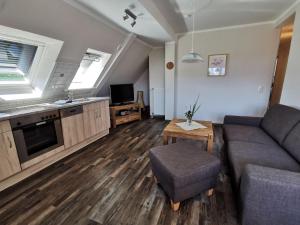 un soggiorno con un divano e un tavolo di Ferienwohnung-Apfelbluete a Presen