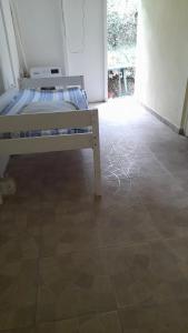 a bed in a room with a tiled floor at Maison chaleureuse à Petit-Bourg in Petit-Bourg