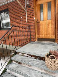 a front door of a brick house with stairs and a basket at Eget hus i Vittjärv in Boden