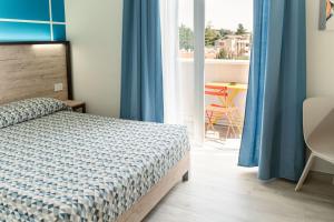 Schlafzimmer mit einem Bett, blauen Vorhängen und einem Tisch in der Unterkunft Maritan Hotel & Spa in Padua