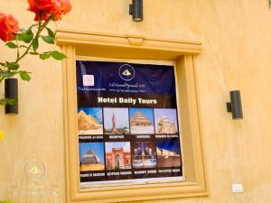 een poster van de dagelijkse rondleidingen van het hotel in een raam bij Sidi Hamad Pyramids INN in Caïro