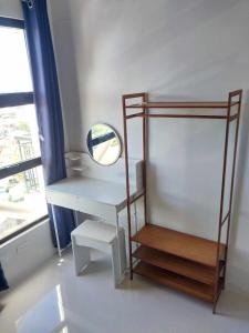 escritorio blanco con espejo y estante en Kazumi Suites, en Sudtungan