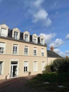 ein großes weißes Gebäude mit Fenstern und einem Dach in der Unterkunft Bel appartement 4 personnes in Port-en-Bessin-Huppain