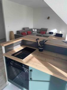 eine Küche mit einem Wohnzimmer mit einem Sofa in der Unterkunft Bel appartement 4 personnes in Port-en-Bessin-Huppain