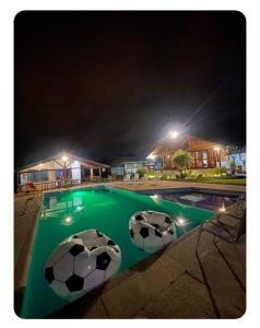 two soccer balls in a swimming pool at night at Quinta Suria in Quito