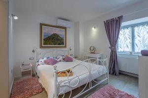 a bedroom with a white bed and a window at Holiday Home Belveder Motovun with heated pool in Livade