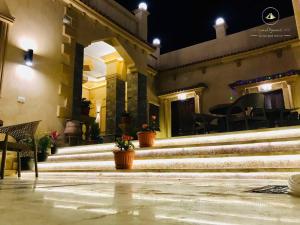 a building with stairs and a table and chairs at Sidi Hamad Pyramids INN in Cairo