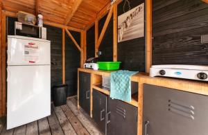 a kitchen with a refrigerator and a stove at Tenthuisje met hottub in Callantsoog in Callantsoog