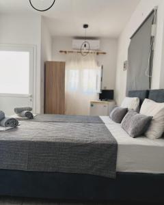 Un dormitorio con una cama grande con almohadas. en Litsa_house, en Skiathos
