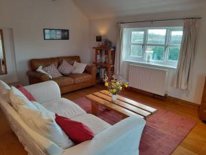 a living room with a couch and a table at The Barn, Poplar Farm in York