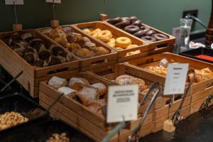 a display of different types of donuts in wooden trays at Aparthotel AnyosPark Mountain & Wellness Resort in Anyós
