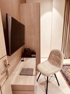 a living room with a chair and a television at The Lodgers 2 BHK Serviced Apartment Near Artemis Hospital Sector 57 Gurgaon - Nearest Metro Station Sector 54 Chowk in Gurgaon