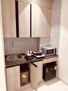 una pequeña cocina con fregadero y microondas en The Lodgers 2 BHK Serviced Apartment Near Artemis Hospital Sector 57 Gurgaon - Nearest Metro Station Sector 54 Chowk, en Gurgaon