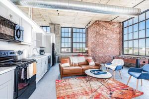a kitchen and living room with a couch and a table at STUNNING Architect loft by CozySuites in Saint Louis