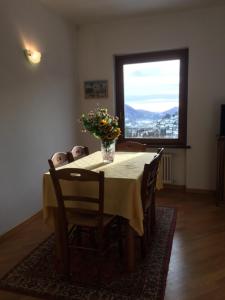 una mesa de comedor con un jarrón de flores. en Appartamento Al Canelino - Como Lake and Mountains en Asso