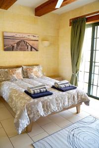 a bedroom with a bed with two towels on it at Casa Sammy in Sannat