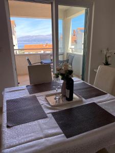 a table with a plate with a vase of flowers on it at Apartman Emil in Supetar