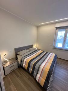 um pequeno quarto com uma cama e uma janela em Casa Sole em Codogno