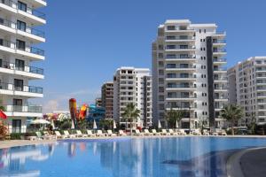 a large swimming pool in front of some buildings at Sea View 2-Bedroom Apartment with Water Park at Caesar Blue Resort in Boğaz +31 photos