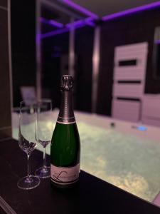 a bottle of wine and two wine glasses on a table at L'Evasion Alpine in Albertville