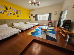 sala de estar con 2 camas y TV en 澎湖紙飛機民宿Paper Jet B&B, en Magong