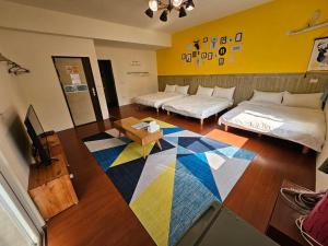 um quarto com duas camas e um tapete colorido em 澎湖紙飛機民宿Paper Jet B&B em Magong