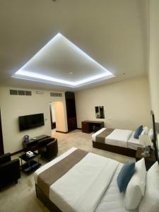 Habitación grande con 2 camas y TV. en A Line Hotel en Doha