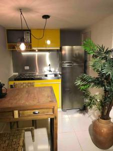 a kitchen with a stainless steel refrigerator and a table at Studio no Jabaquara a 2,8km da Expo imigrantes in Sao Paulo